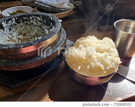 Stone-cooked rice with smoke rising 75008501