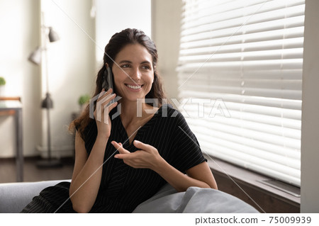 Close up smiling woman talking on phone, enjoying pleasant conversation Close up smiling woman talking on phone, enjoying pleasant conversation 75009939
