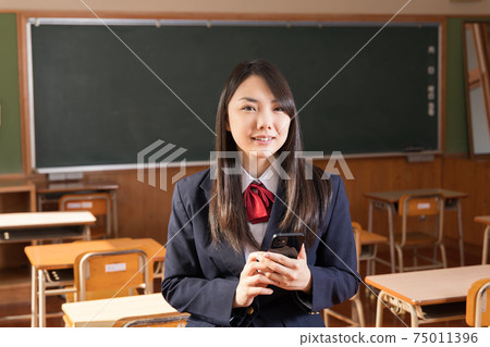 高中女生,高中生,用智能手機站在教室裡 高中女生,高中生,用智能手機站在教室裡 75011396