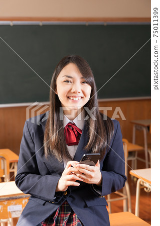 高中女生，高中生，用智能手機站在教室裡 75011399