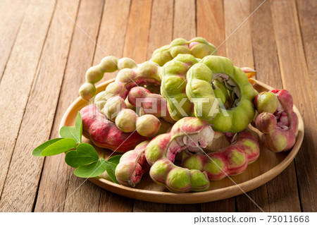 Manila tamarind fruit (Pithecellobium dulce) on wooden plate background. Manila tamarind fruit (Pithecellobium dulce) on wooden plate background. 75011668