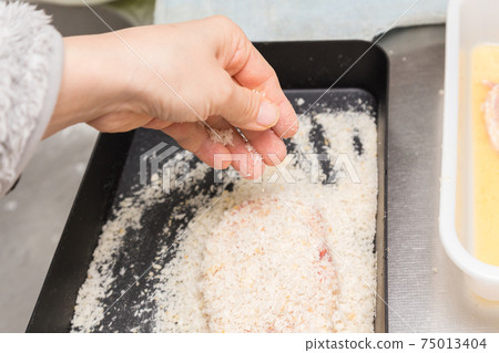 Hands of a woman preparing pork cutlet 75013404
