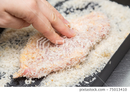 Hands of a woman preparing pork cutlet 75013410