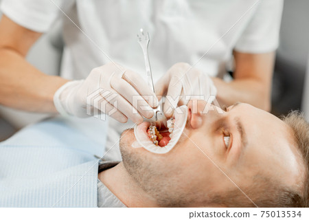 Patient with dental braces during a regular orthodontic visit 75013534