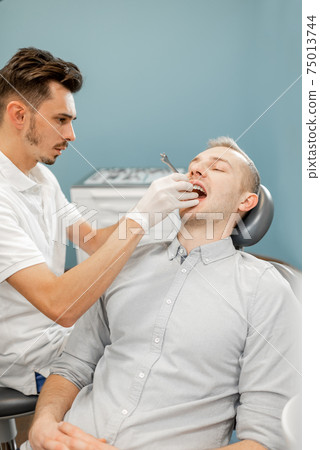 Dentist and patient during an orthodontic treatment 75013744