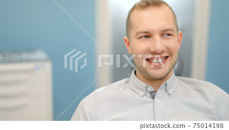 Portrait of a male patient wearing dental braces 75014198