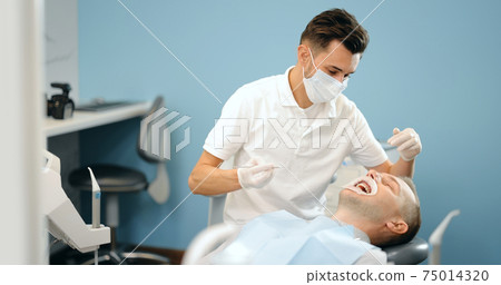 Dentist and patient during an orthodontic treatment 75014320