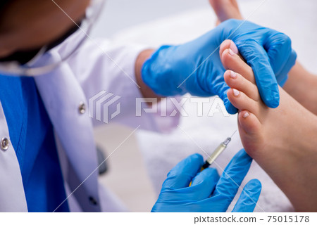 Podiatrist treating feet during procedure 75015178
