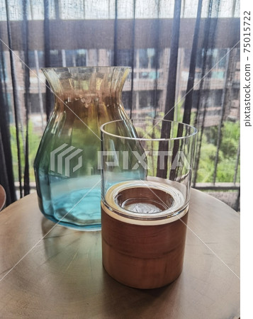 Candlestick and vase on a wooden table 75015722