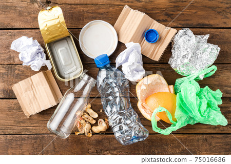 Overhead shot of different kinds of garbage - plastic, glass, paper, metal, plastic and organic. Waste management concept. Flat lay Overhead shot of different kinds of garbage - plastic, glass, paper, metal, plastic and organic. Waste management concept. Flat lay 75016686