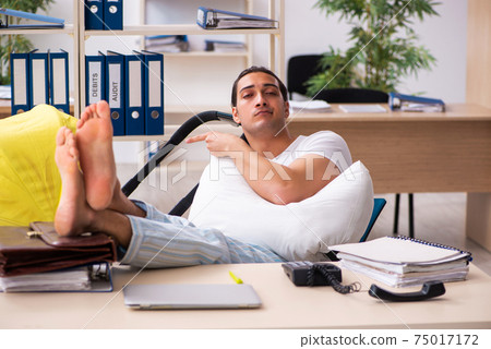 Young male employee looking after newborn at workplace Young male employee looking after newborn at workplace 75017172
