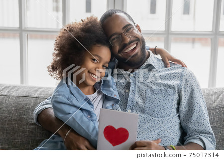 Portrait of happy father and daughter kid holding postcard 75017314