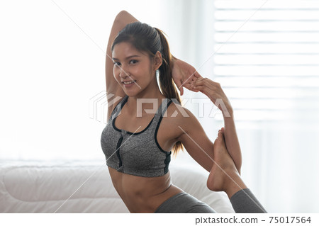 Attractive Asian woman practice yoga king pigeon pose to meditation at home Feeling so calm comfortable and relax,Yoga for Healthcare Concept 75017564