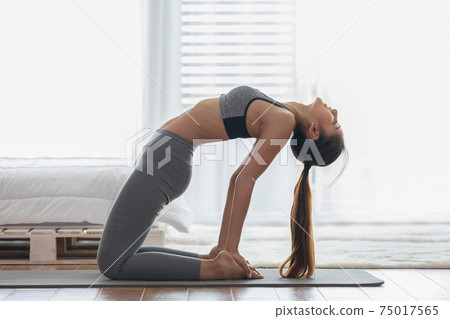 Attractive Asian woman practice yoga Ustrasana pose or yoga Camel pose to meditation in bedroom after wake up in the morning Feeling so comfortable and relax,Yoga for Healthcare Concept Attractive Asian woman practice yoga Ustrasana pose or yoga Camel pose to meditation in bedroom after wake up in the morning Feeling so comfortable and relax,Yoga for Healthcare Concept 75017565