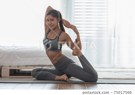 Attractive Asian woman practice yoga king pigeon pose to meditation at home Feeling so calm comfortable and relax,Yoga for Healthcare Concept Attractive Asian woman practice yoga king pigeon pose to meditation at home Feeling so calm comfortable and relax,Yoga for Healthcare Concept 75017566