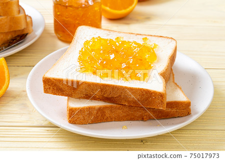 Slices of bread with orange jam 75017973