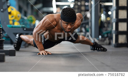 Motivated black guy bodybuilder doing some push-ups Motivated black guy bodybuilder doing some push-ups 75018782
