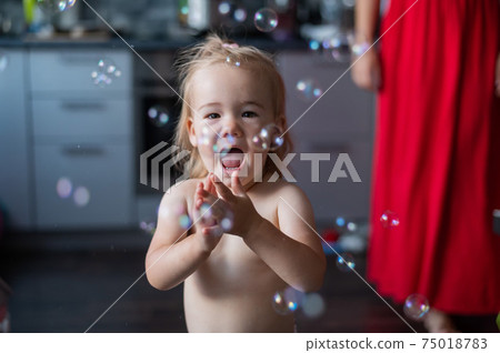 Little Caucasian Girl enjoys soap bubbles. Little Caucasian Girl enjoys soap bubbles. 75018783