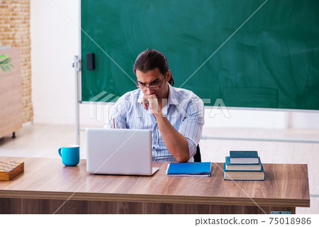 Young male teacher in tele-education concept in the classroom 75018986