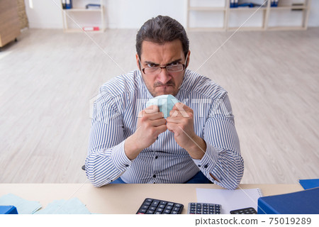 Young male bookkeeper calculating tax payments in the office 75019289