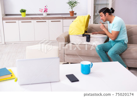 Young male parent looking after newborn at home Young male parent looking after newborn at home 75020174