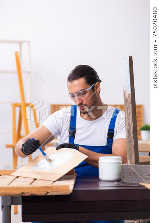 Young male contractor working in workshop 75020480