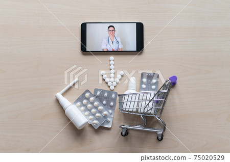Friendly female doctor on a smartphone screen prescribes treatment. Online medicine. Mini trolley with pills. Remote consultation. Mobile application pharmacy. Friendly female doctor on a smartphone screen prescribes treatment. Online medicine. Mini trolley with pills. Remote consultation. Mobile application pharmacy. 75020529