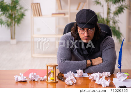 Young male writer in time management concept Young male writer in time management concept 75020865