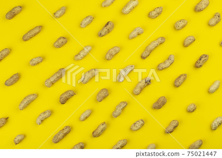 Peanuts pattern isolated on a yellow backround. Repetition concept. Peanuts pattern isolated on a yellow backround. Repetition concept. 75021447