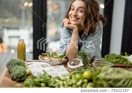 Woman cooking healthy green salad in kitchen 75022187