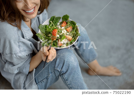 Woman with healthy salad on the kitchen 75022190