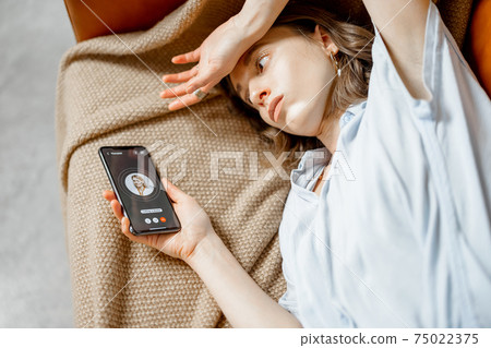 Woman feel bad lying on sofa and call a doctor 75022375