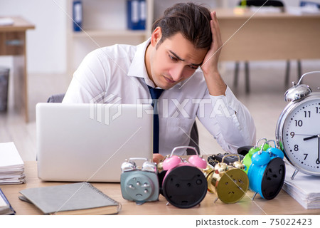 Young male employee afraid of missing deadline at workplace 75022423