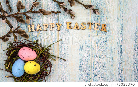 Happy Easter. Willow twigs. Holy Easter. Blue turquoise background. Easter eggs in the nest Happy Easter. Willow twigs. Holy Easter. Blue turquoise background. Easter eggs in the nest 75023370
