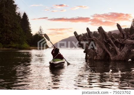 Adventurous Girl kayaking in the Pacific Ocean. 75023702