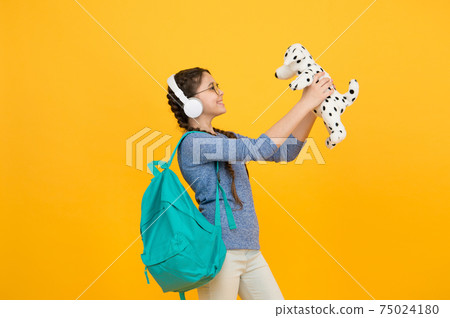 Learning through play. Happy girl play with soft dog. 75024180