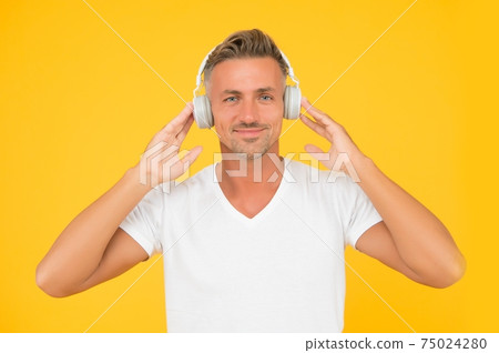 Middle-aged caucasian man wear headphones modern technology yellow background, hearing Middle-aged caucasian man wear headphones modern technology yellow background, hearing 75024280