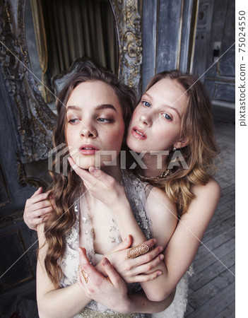 two pretty twin sister blond curly hairstyle girl in luxury house interior together, rich young people concept two pretty twin sister blond curly hairstyle girl in luxury house interior together, rich young people concept 75024550