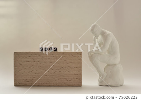 A person who thinks next to the alphabet beads called SDGs 75026222