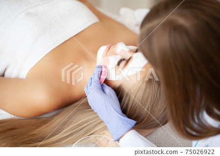 Spa Woman applying Facial cleansing Mask, Beauty Treatments 75026922