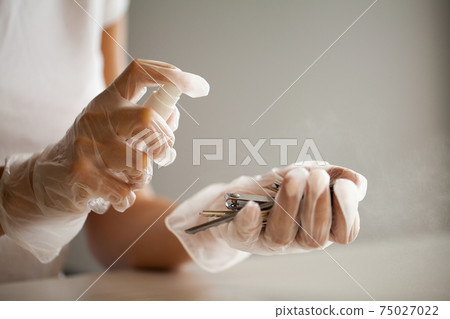 Woman disinfecting keys with disinfectant on the table Woman disinfecting keys with disinfectant on the table 75027022