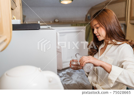 woman drinking water and living in a camper RV van motorhome woman drinking water and living in a camper RV van motorhome 75028665