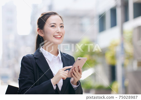 在辦公區使用智能手機的求職大學生 在辦公區使用智能手機的求職大學生 75028987