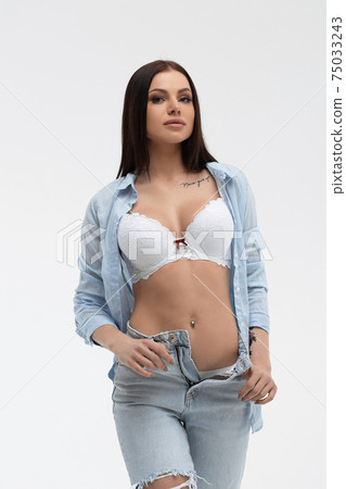 Sensual woman in brassiere and casual apparel on light background Sensual woman in brassiere and casual apparel on light background 75033243