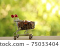 Shopping cart - trolley and coins on wood. Expense, shopping and financial and banking concept. 75033404