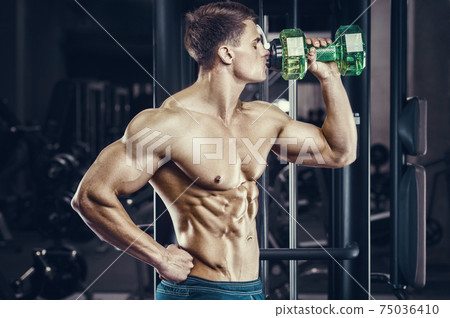 Bodybuilder drinking water after fitness workout. Bodybuilder drinking water after fitness workout. 75036410