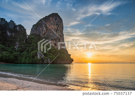 Tropical islands sunset view with ocean blue sea water and white sand beach at Railay Beach, Krabi Thailand nature landscape Tropical islands sunset view with ocean blue sea water and white sand beach at Railay Beach, Krabi Thailand nature landscape 75037137