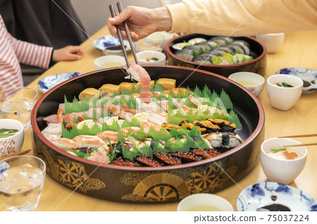 Family eating delivery sushi at home Family eating delivery sushi at home 75037224