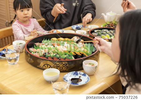 Family eating delivery sushi at home 75037226