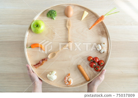 Intermittent fasting diet concept with 8-hour clock timer for eating nutritional or keto low carb, high protien food meal healthy dish and 16-hour skipping meal for weight loss Intermittent fasting diet concept with 8-hour clock timer for eating nutritional or keto low carb, high protien food meal healthy dish and 16-hour skipping meal for weight loss 75037809